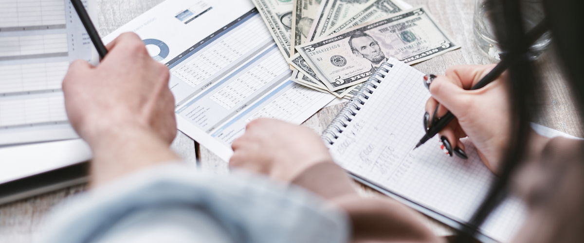 Two people checking payment reconciliation records.